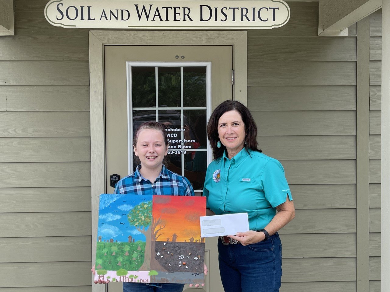 In the above photo, Program Specialist with the Okeechobee Soil & Water Conservation District Robbi Sumner presents Lillian Stead with her award check.